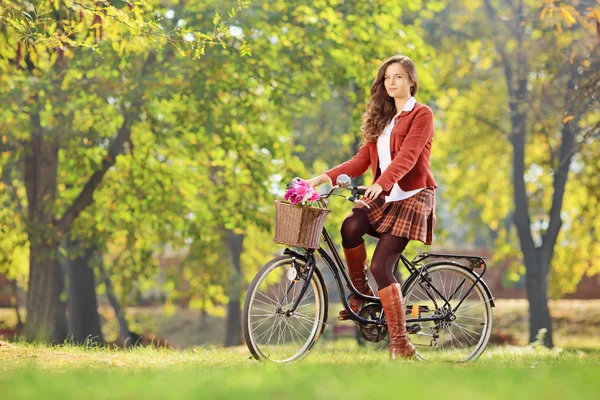 Kvinna på en cykel i en park — Stockfoto