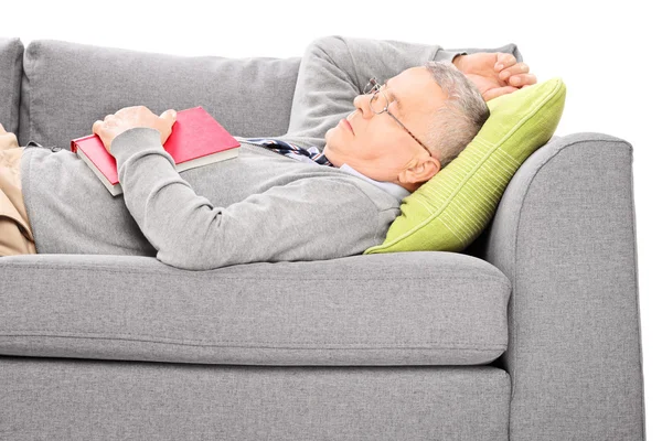 Homem dormindo no sofá e segurando livro — Fotografia de Stock