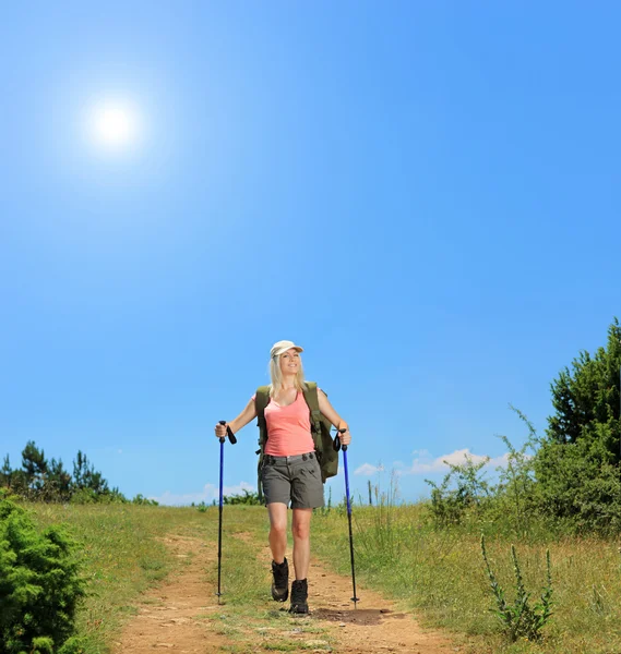 Donna con bastoni da trekking a piedi — Foto Stock