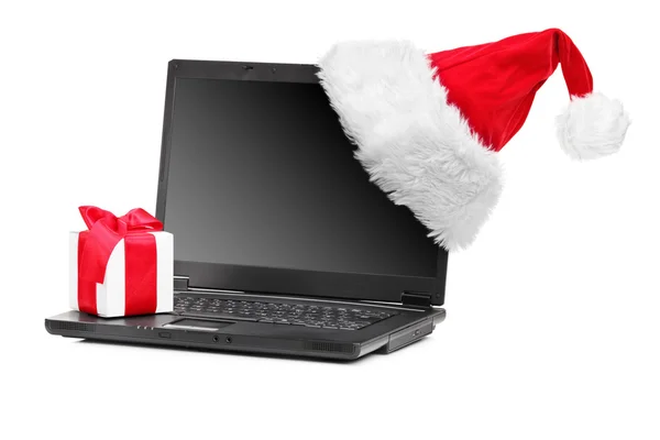 Santa hatt och gåva på en bärbar dator — Stockfoto
