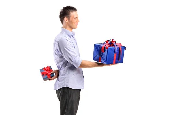 Hombre dando gran regalo y escondiendo uno pequeño — Foto de Stock