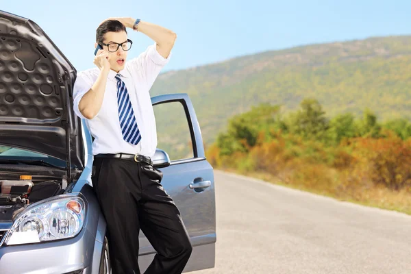 Sad male on broken car talking on phone — Stock Photo, Image