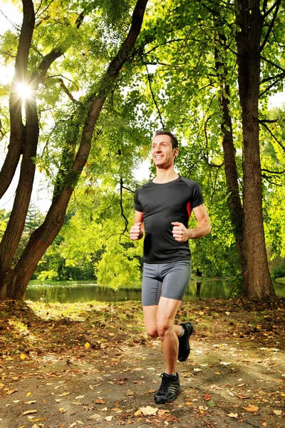 Athlete jogging on trail in park — Stock Photo, Image