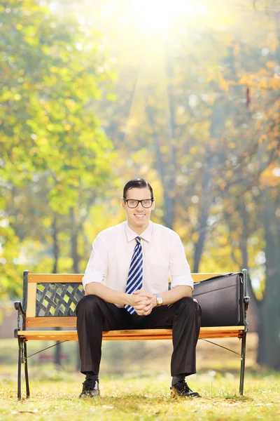 Businessman sitting on wooden bench — Stock Photo, Image