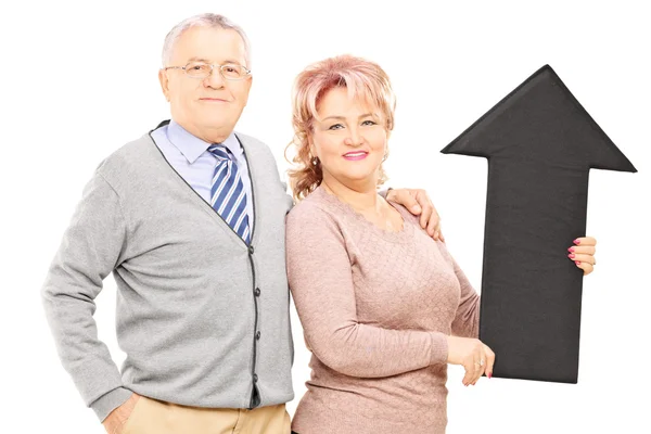 Mature couple holding black arrow — Stock Photo, Image