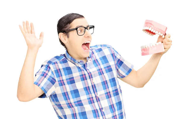 Scared man holding teeth sample — Stockfoto