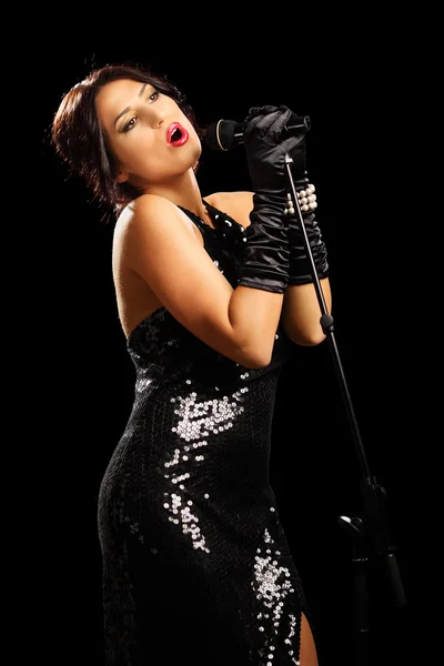 Mujer en vestido negro cantando — Foto de Stock