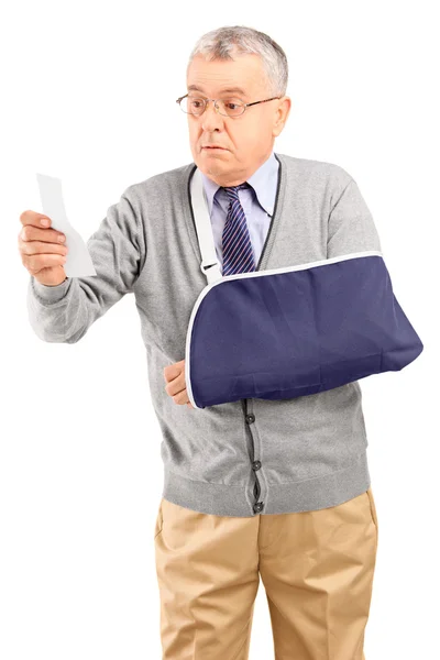 Man with broken arm looking at receipt — Stock Photo, Image