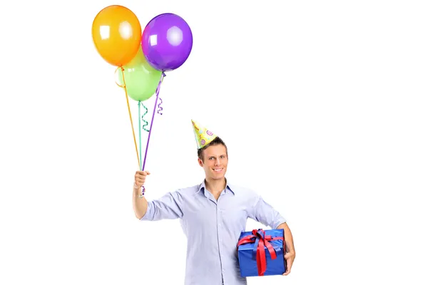 Człowiek posiadający obecny i balony — Zdjęcie stockowe