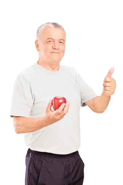 Man houden een appel en duim opgevend — Stockfoto