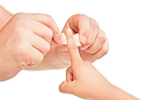 Dad putting plaster on sons finger — Stock Photo, Image