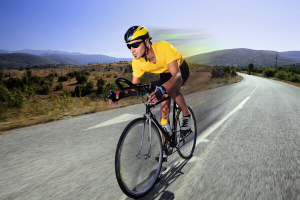 Cyclist riding bike on road