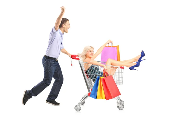 Person pushing woman shopping cart — Stock Photo, Image