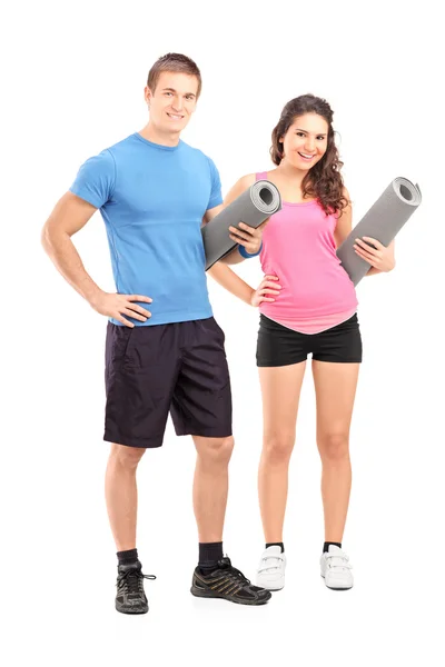 Young athletes holding exercising mats — Stock Photo, Image