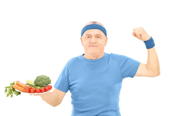 Homme tenant une assiette pleine de légumes — Photo