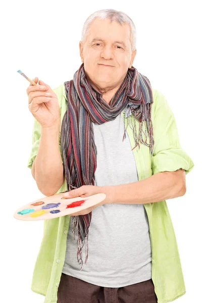 Artista madura segurando uma palete e um pincel — Fotografia de Stock