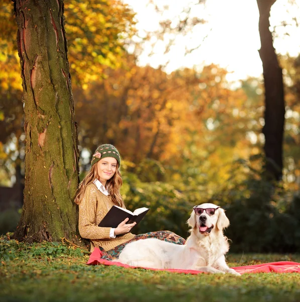 Woman relaxing in park with dog — Stock Photo, Image