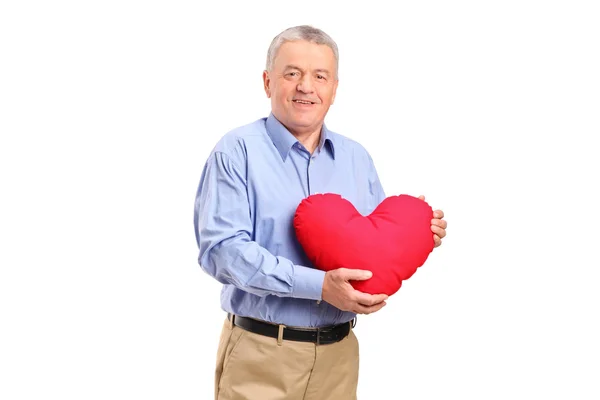Hombre sosteniendo almohada en forma de corazón — Foto de Stock
