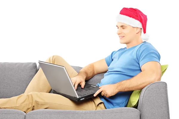 Guy with santa hat working on laptop Royalty Free Stock Photos