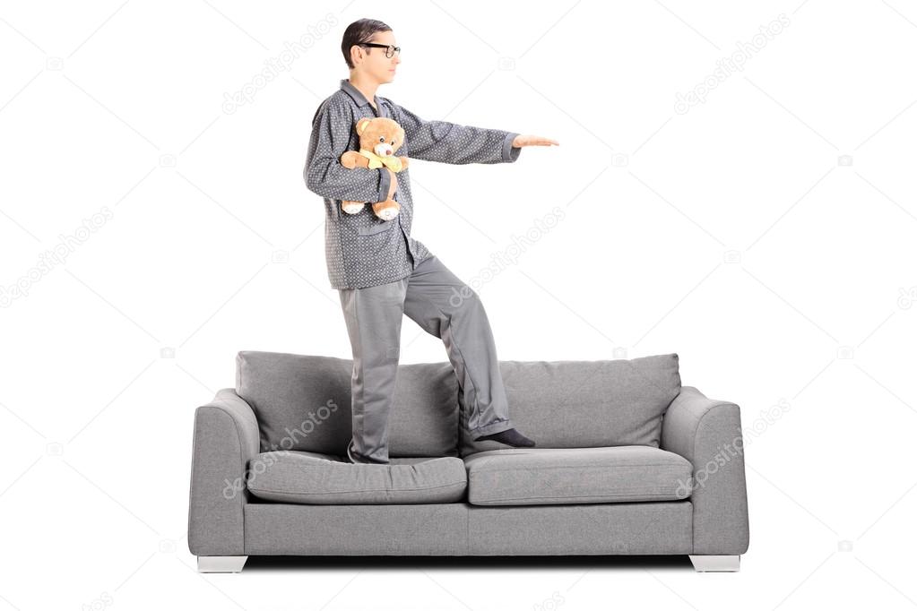Man in pajamas sleepwalking on sofa