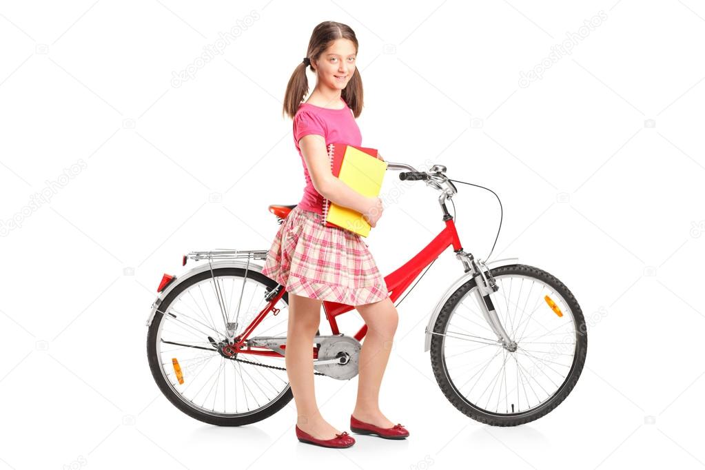 Girl holding notebooks and bike