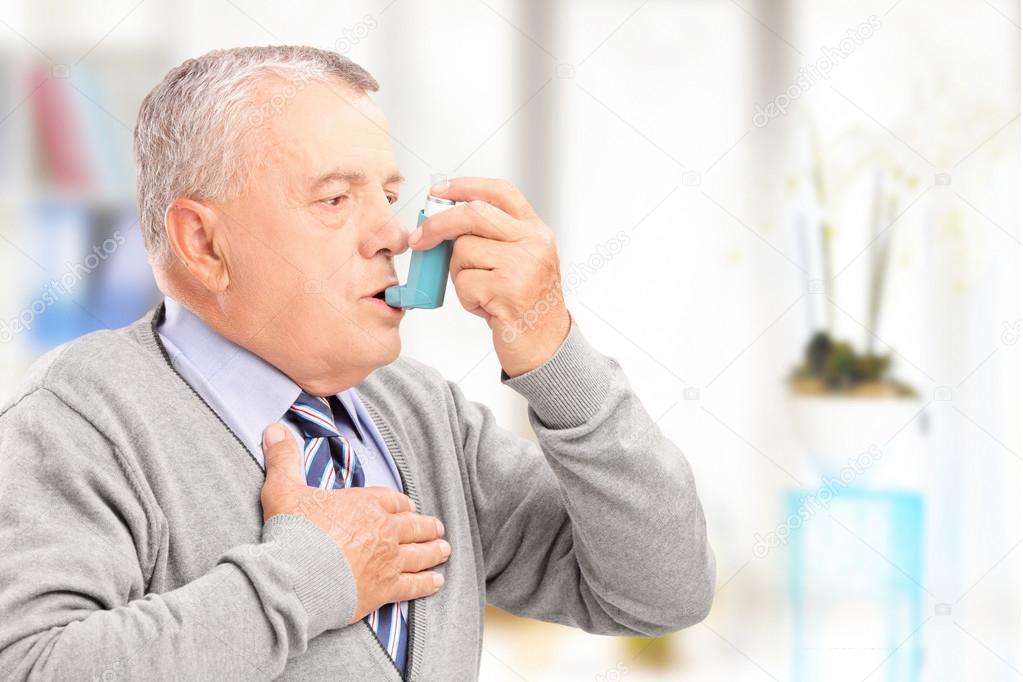 Man treating asthma with inhaler