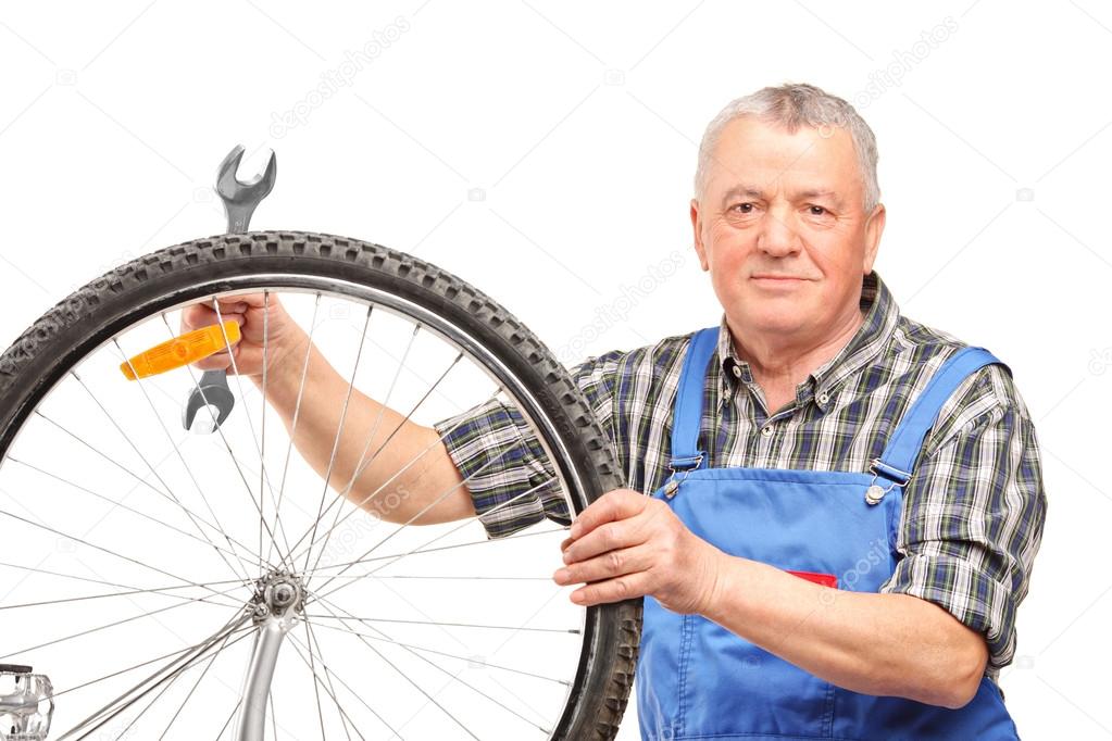 man repairing bicycle wheel