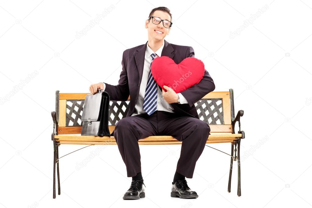 Smiling businessman holding red heart