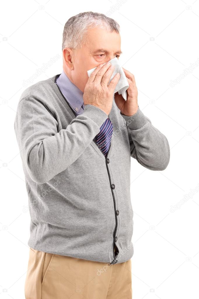Man blowing his nose in tissue