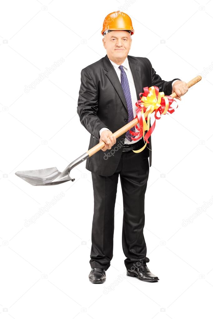 Mature businessman holding shovel