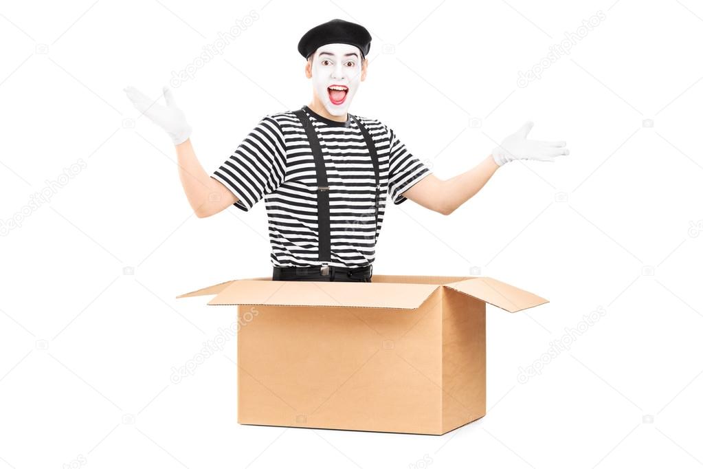 Mime artist sitting in carton box