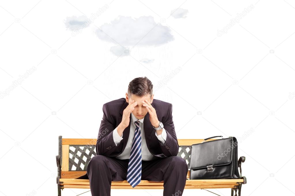 Stressed businessman sitting on bench