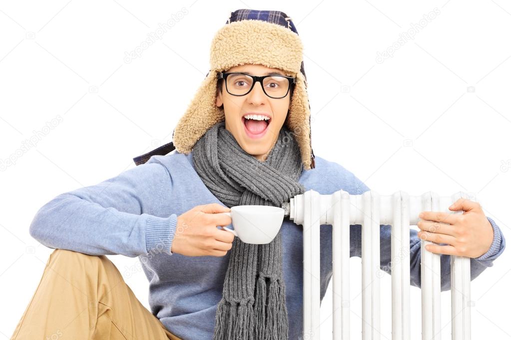 Man sitting next to radiator with tea