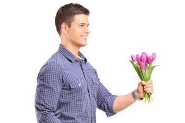 Smiling guy holding flowers
