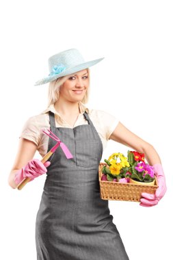 bir kazma ve sepeti tutan kadın bahçıvan 