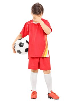 Futbol topu ile üzgün çocuk