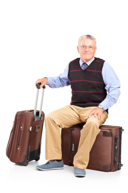 seyahat çanta üzerinde oturan adam