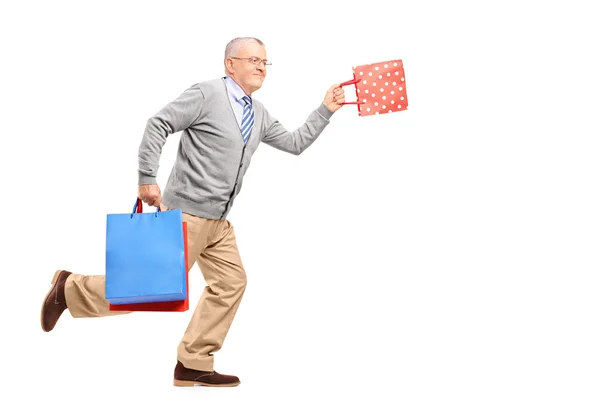 Cavalheiro correndo com sacos de compras — Fotografia de Stock