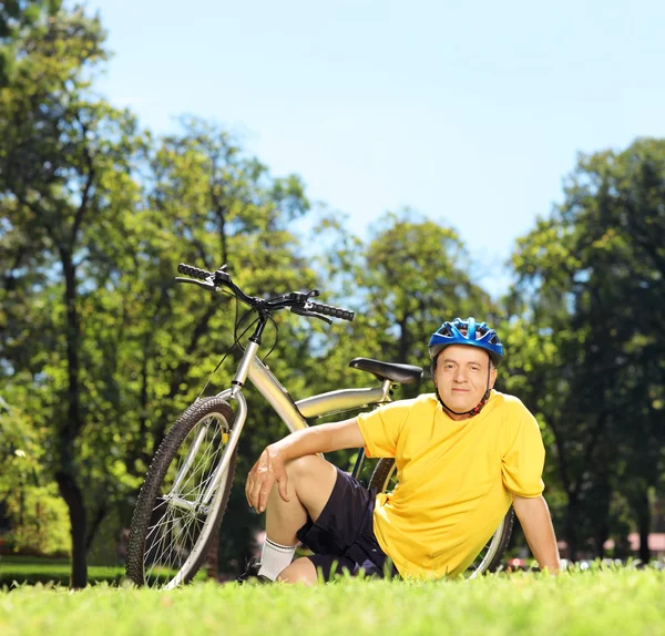 Volwassen man in in de buurt van zijn fiets — Stockfoto