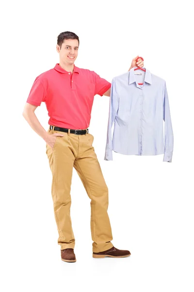 Homem segurando uma camisa em um cabide — Fotografia de Stock