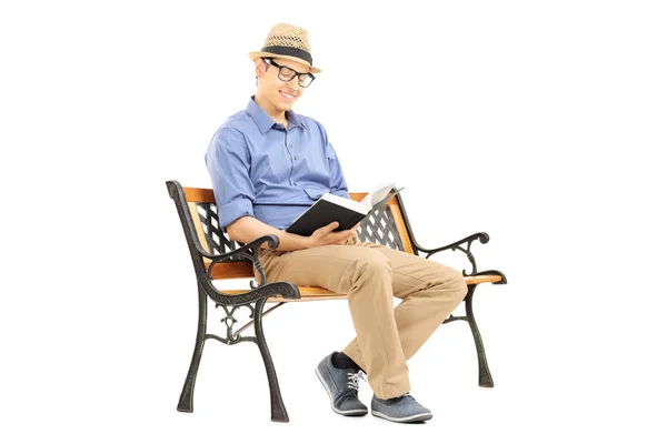 Homem lendo um livro no banco — Fotografia de Stock