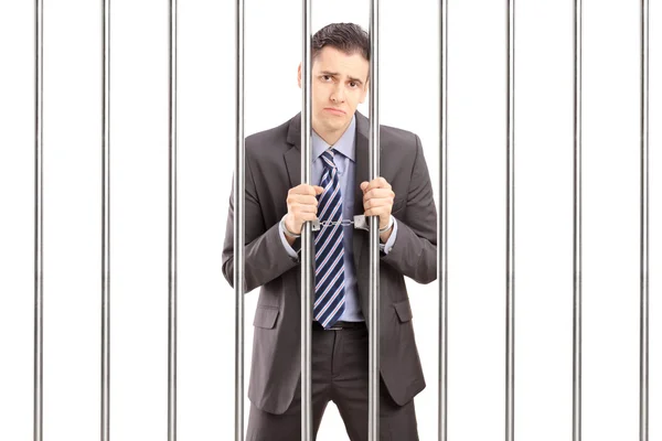 Sad handcuffed businessman in jail — Stock Photo, Image