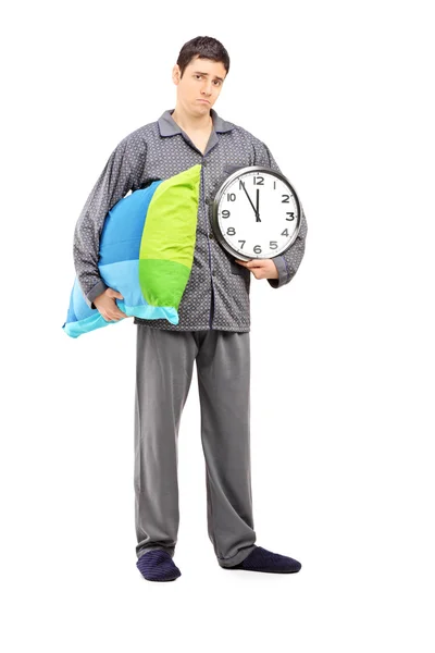 Sleepy guy holding clock and pillow — Stock Photo, Image