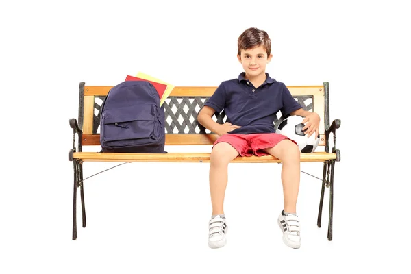 Schoolboy sitting on bench with football — Stock Photo, Image