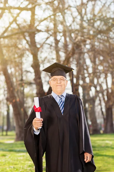 Зрелый мужчина, позирующий с дипломом — стоковое фото