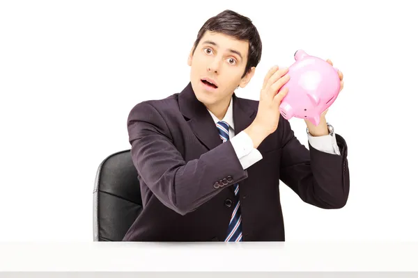 Zakenman luisteren naar een piggy bank — Stockfoto