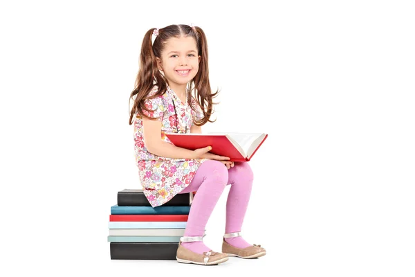 Chica sentada en la pila de libros —  Fotos de Stock