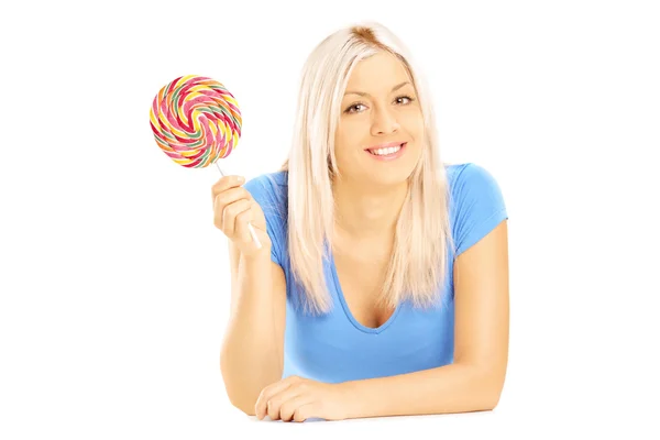 Female lying down with lollipop — Stock Photo, Image