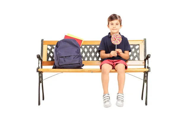 Menino da escola segurando pirulito doce — Fotografia de Stock