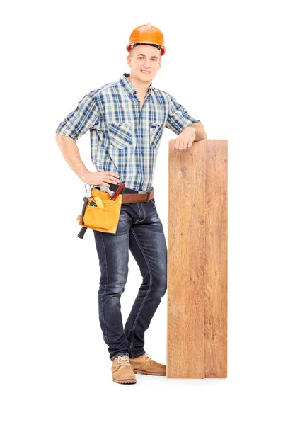 Плотник-мужчина, опирающийся на доску — стоковое фото